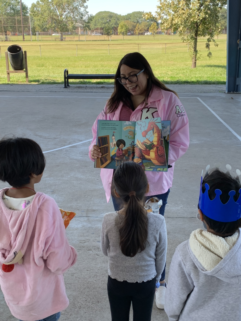 Early learners, young Houston students, read in park at community event in Gulfton.
