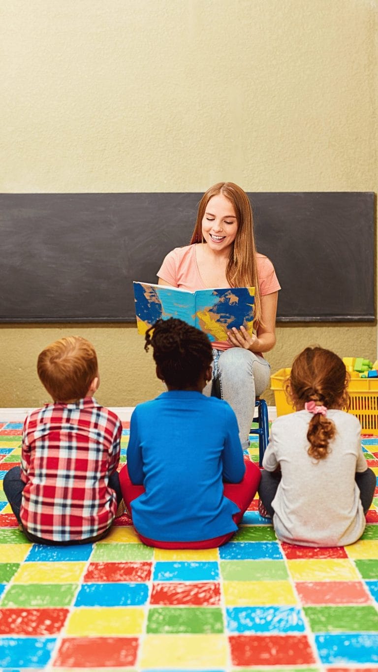 Teacher reading to three young students