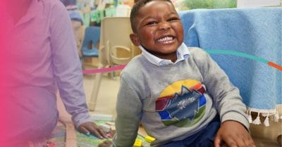 Young boy smiling in early learning environment, representing Houston's commitment to quality early childhood education and kindergarten readiness